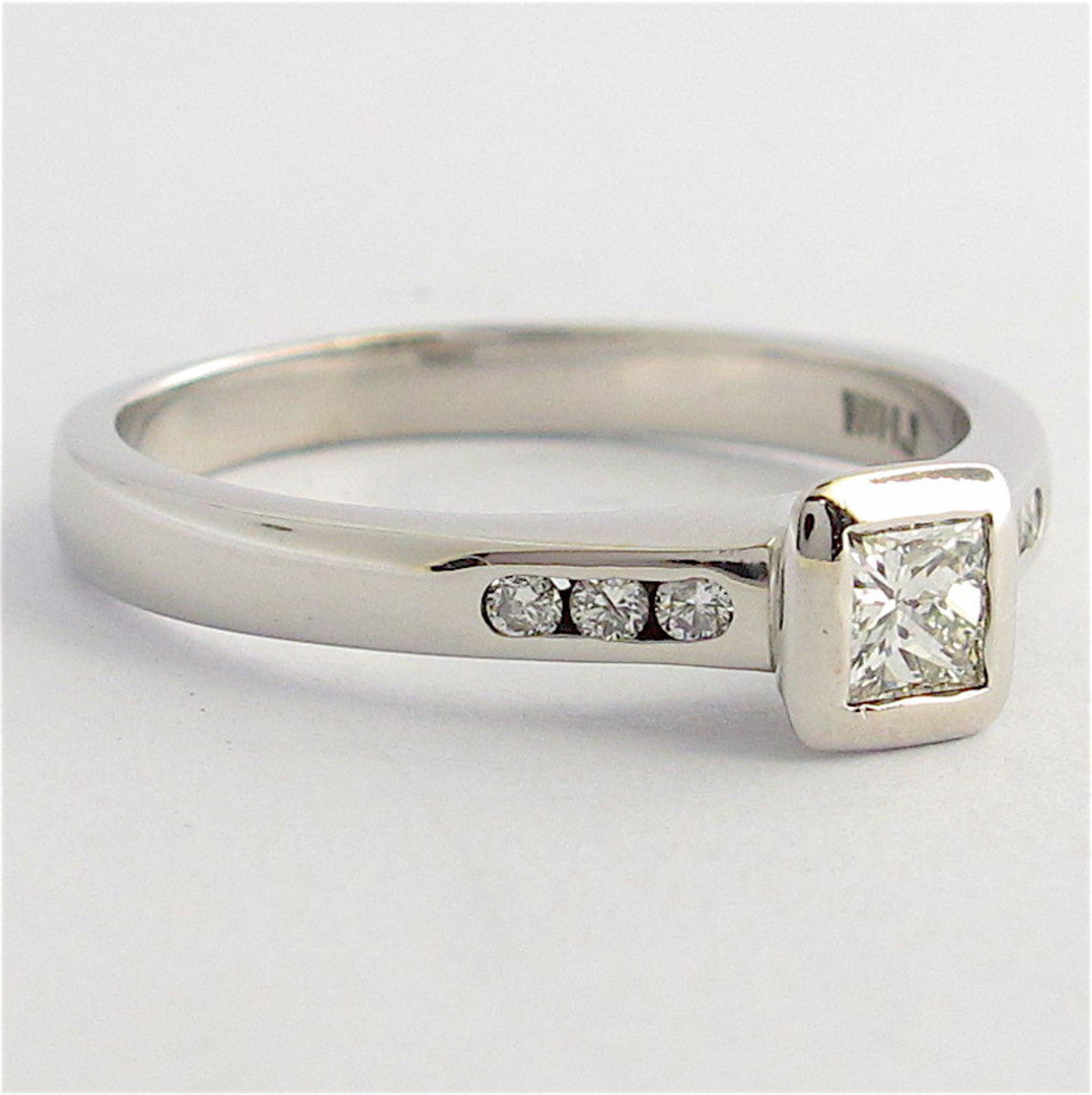 18ct white gold diamond solitaire ring with channel set diamond shoulder detail image 1