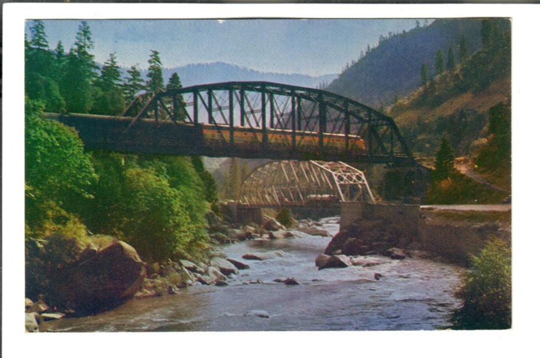USA Coloured postcard of Streamliner crossing Feather River on the high bridge as highway traffic travels on the lower bridge. - image 0