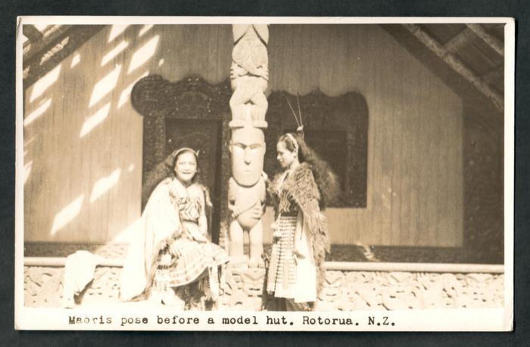 Real Photograph by N S Seaward of Maoris pose before a model hut Rotorua. - 49666 - Postcard image 0