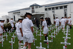 Naval personnel walk among the crosses
