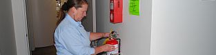 Woman Inspecting Fire Extinguisher