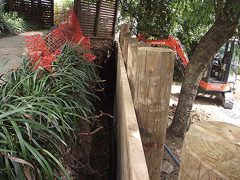 Newly installed timber pole and rail retaining wall