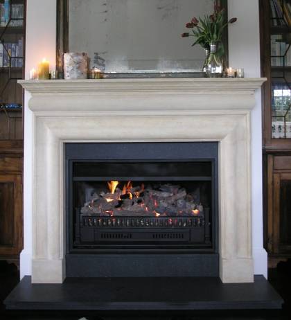 Bolection style fireplace mantle carved in Oamaru Limestone with aged patina