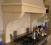 Kitchen range hood hand carved in Oamaru Limestone with aged patina