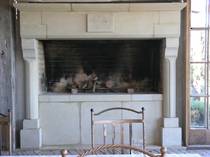 Large Gothique Loggia fireplace with raised firebox carved in Hinuera Stone