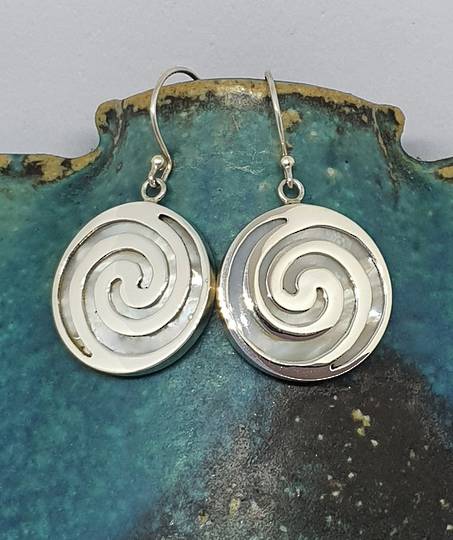 Round mother of pearl earrings overlaid with koru spirals