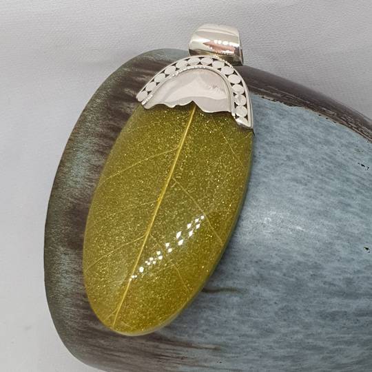 Green skeleton leaf pendant set in sterling silver