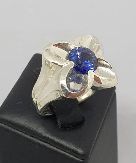 Silver flower ring with sparkling deep blue stone