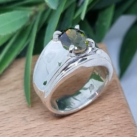 Wide silver band ring with green gemstone